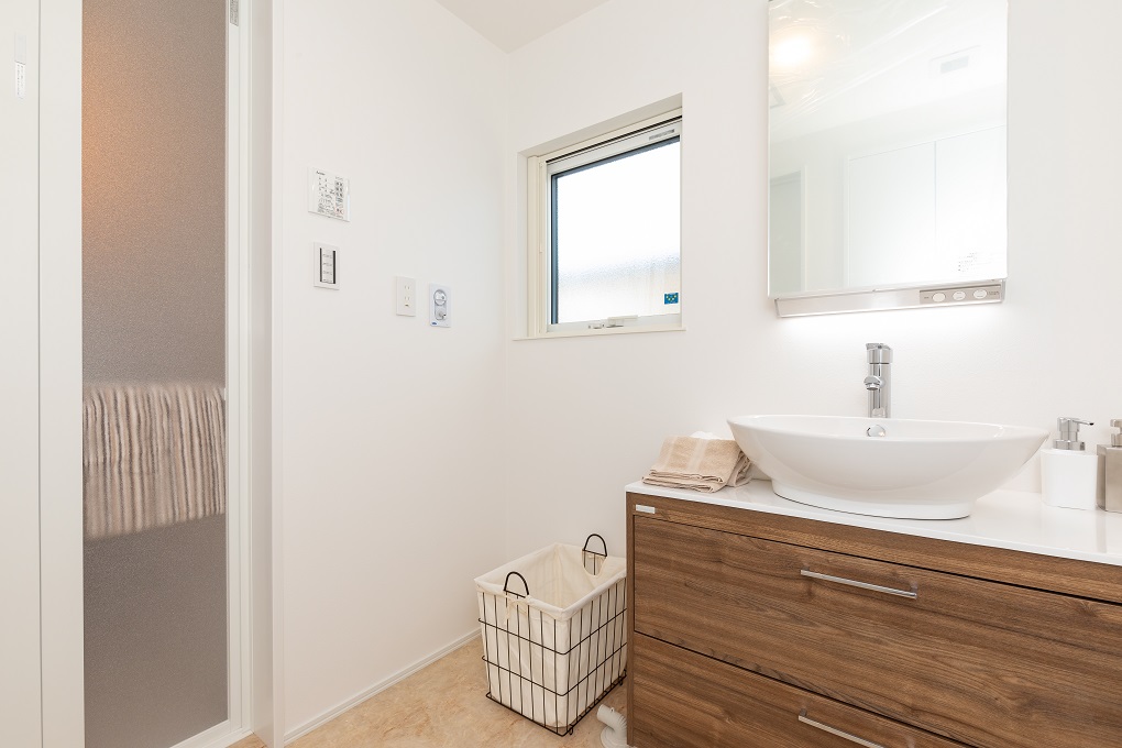 シンプルな洗面台の背面には大きな収納あり