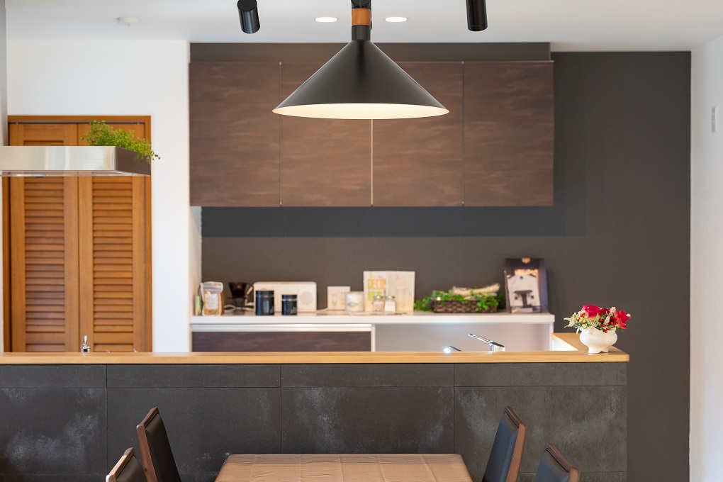 お洒落なキッチンの腰壁の板材には本物のセメントを使用しており色むらや風合いを楽しめる