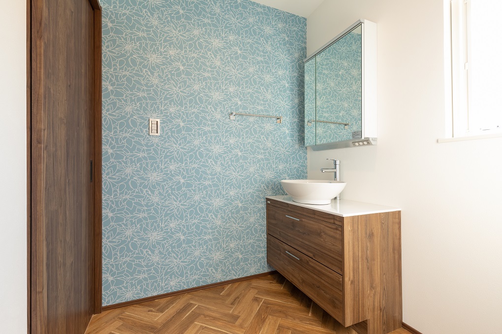 水色のアクセントクロスが洗面室を明るくします